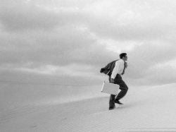 Рисунок мужчины, который с чемоданом идет по пустыне